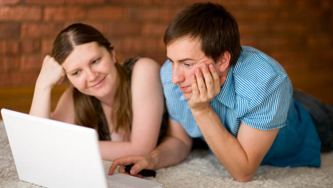 Young couple working on laptop at their home